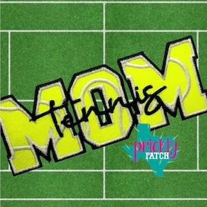 May include: Embroidered patch with the word "MOM" in large, yellow, block letters with a black outline, and the word "Tennis" in black script. The patch has a green background with white lines, and a Texas-shaped logo.