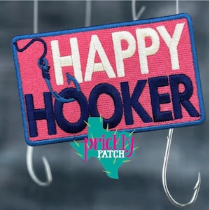 May include: Embroidered patch with the words "HAPPY HOOKER" in white and navy blue on a pink background. A blue fishing hook is featured on the left side. The patch is rectangular with a blue border. The Prickly Patch logo is at the bottom.