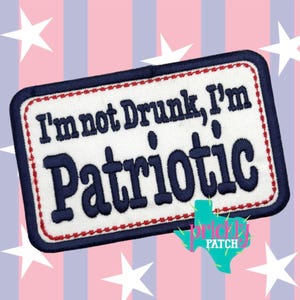 May include: Embroidered patch with the text "I'm not Drunk, I'm Patriotic" in navy blue on a white background. The patch has a navy blue border with a red stitched edge. The background features a patriotic design with stars and stripes.