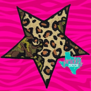 May include: A star-shaped embroidered patch featuring a split design with a tan and black leopard print on one side and a green, brown, and black camouflage pattern on the other. The patch has a black stitched border and a teal Texas-shaped logo.