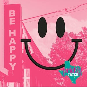 May include: A pink graphic featuring a large black embroidered smiley face with oval eyes and a curved mouth. The image includes a pink sign that reads "BE HAPPY" and a teal and pink logo that says "prickly patch".
