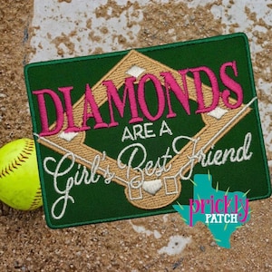 May include: A green embroidered patch with the words "DIAMONDS ARE A Girl's Best Friend" in pink and white. The design includes a baseball diamond and a softball. A yellow softball is on the left.