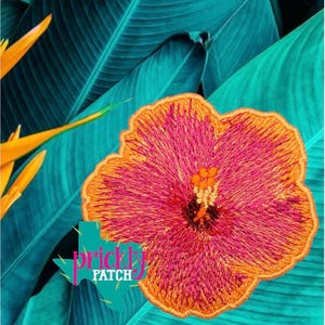 May include: Embroidered patch featuring a vibrant hibiscus flower in shades of pink and orange, set against a backdrop of teal tropical leaves. The patch has a detailed design and the text "Prickly Patch" in a teal Texas outline.