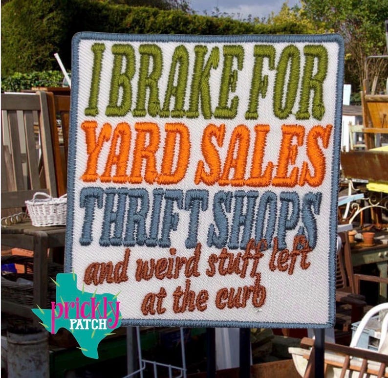 Może przedstawiać: Haftowana naszywka z napisem "I Brake For Yard Sales Thrift Shops and weird stuff left at the curb." Naszywka ma białe tło z zielonymi, pomarańczowymi, niebieskimi i brązowymi literami. Logo w kształcie Teksasu znajduje się w lewym dolnym rogu.