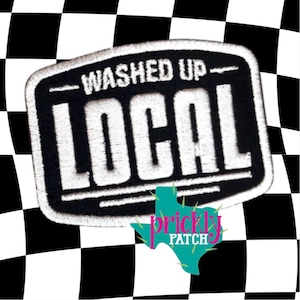 May include: Embroidered patch with the words "Washed Up Local" in white on a black rectangular background. The patch has a white border and is set against a black and white checkered background. The Prickly Patch logo is at the bottom.