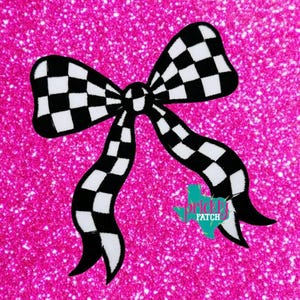 May include: A black and white checkered bow patch featuring a repeating square pattern. The bow has two large loops and two long, flowing tails. A small teal-colored logo with the text Prickly Patch is visible near the bottom right tail.