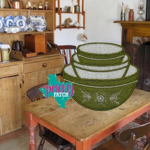May include: A set of four green and white nesting bowls with a floral design. The bowls are stacked on a wooden table in a rustic kitchen setting. The bowls are a vintage style.