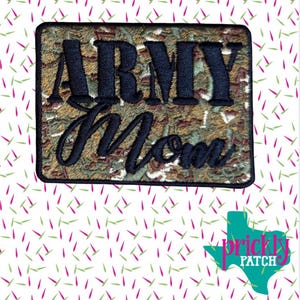 May include: Embroidered patch with the words "ARMY Mom" in black thread. The background has a camouflage pattern in shades of green, brown, and tan. The patch is rectangular with a black border. The Prickly Patch logo is in the bottom right corner.