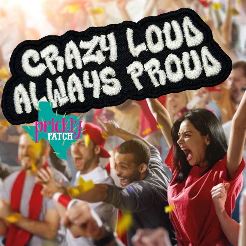 May include: Black embroidered patch with the words "CRAZY LOUD ALWAYS PROUD" in white, wavy lettering. The patch is in front of a crowd of cheering people, with the Prickly Patch logo at the bottom.
