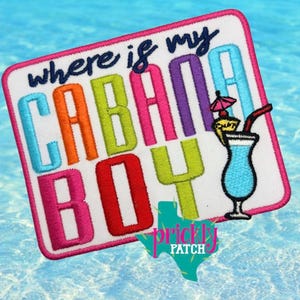 May include: Embroidered patch with the phrase "where is my cabana boy" in colorful letters. A blue cocktail with a straw and umbrella is on the right. The patch has a pink border and a Texas-shaped logo.