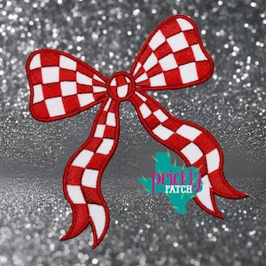 May include: An embroidered patch in the shape of a bow featuring a red and white checkered pattern. The bow has two large loops and two trailing ribbons. A teal-colored logo shaped like the state of Texas with the text Prickly Patch is visible.