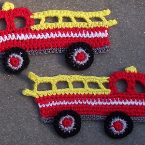 May include: Two red and yellow crocheted fire truck appliques with black wheels and white accents.
