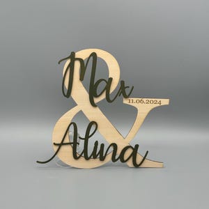 May include: Wooden ampersand sign with the names Max and Alina and the date 11.06.2024.