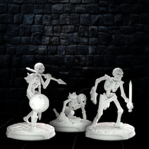 May include: Three white plastic miniature skeletons, one standing with a sword, one standing with a spear, and one crawling on all fours. The skeletons are on circular bases.