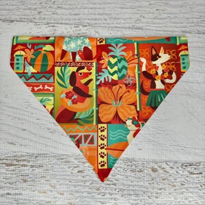 May include: A colourful dog bandana with a tropical theme. The bandana features a variety of animals, including dogs, cats, and a pineapple. The bandana is made of a soft, comfortable fabric and is perfect for any dog who loves to be stylish.