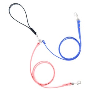 Puede incluir: Tres correas para perros, una negra, una azul y una rosa, conectadas con un clip de metal.