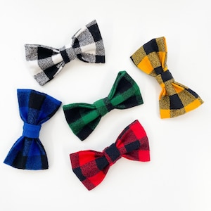 May include: Five plaid bow ties in different colors: black and white, blue and black, green and black, red and black, and yellow and black.