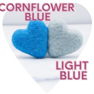 May include: Two felt hearts, one cornflower blue and one light blue. The hearts are side by side on a white surface.