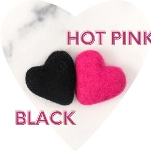 May include: Two felt hearts, one black and one hot pink, on a white marble background. The text "HOT PINK" is above the pink heart and the text "BLACK" is below the black heart.