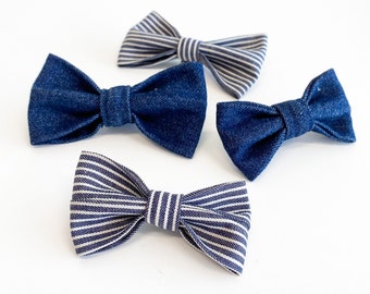 May include: Four bow ties in blue and white. Two are made of denim and two are striped.