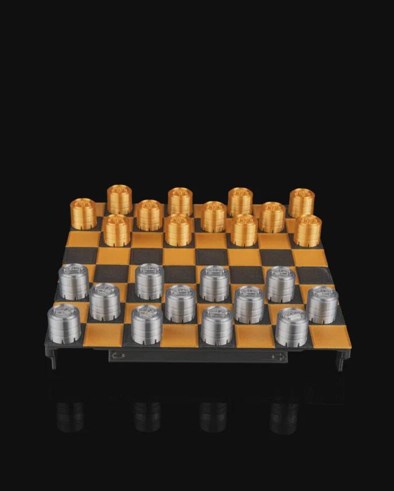 May include: A complete checkerboard set with gold and silver pieces. The board has a black and gold checkered pattern. The pieces are cylindrical and arranged on the board, ready for play. The background is black.