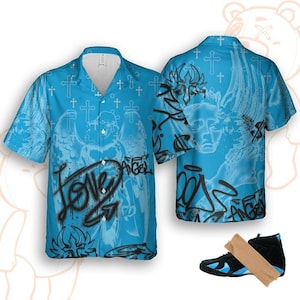 May include: A light blue button-up shirt with a graffiti-style angel design and the word "LOVE". The shirt is paired with black and blue sneakers. The back of the shirt also features an angel design.