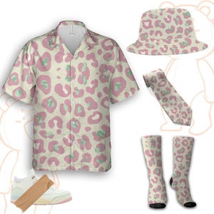 Könnte beinhalten: Eine Kollektion von Kleidung und Accessoires mit einem rosa und grünen Leopardenmuster. Artikel sind ein kurzärmeliges Hemd, ein Fischerhut, eine Krawatte und Socken. Ein Paar weiße Turnschuhe mit rosa Akzenten ist ebenfalls enthalten.