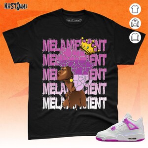 May include: Black t-shirt with the text "MELANIN" repeated in a layered design. The text is in a white font with a purple outline. A black woman with a purple afro and a gold crown is in the center of the design. The woman is looking to the right. The t-shirt is paired with white and purple sneakers.