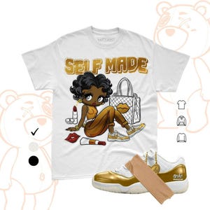 May include: White t-shirt with a gold "SELF MADE" graphic and a cartoon illustration of a woman with a handbag, lipstick, and gold sneakers. Gold and white sneakers with a gold tag are in the foreground.
