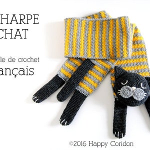 May include: A crocheted cat scarf with yellow and gray stripes. The scarf has a black cat head with gray ears and a black nose. The text "ÉCHARPE CHAT modèle de crochet français" is visible in the image.