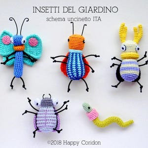 May include: A collection of five colorful, crocheted insect figures. The insects include a butterfly, a beetle, and a worm, each with unique designs and colors. The text "INSETTI DEL GIARDINO" is at the top.