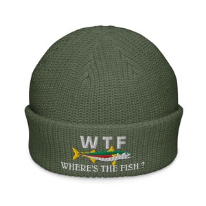 Könnte beinhalten: Olivgrüne Strickmütze mit dem gestickten Text "WTF" über einer bunten Fischgrafik. Unter dem Fisch steht der Text "WHERE'S THE FISH?". Die Mütze hat einen gefalteten Saum.