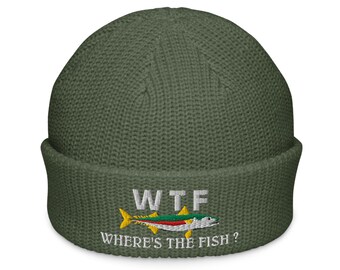 May include: Olive green knit beanie with the embroidered text "WTF" above a colorful fish graphic. Below the fish, the text reads "WHERE'S THE FISH?". The beanie has a folded cuff.