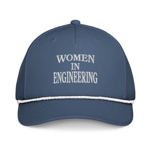 Könnte beinhalten: Marineblaue Kappe mit dem gestickten Text "WOMEN IN ENGINEERING" in Weiß. Die Kappe hat ein weißes Seildetail am Rand.