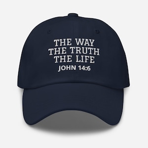 May include: Navy blue baseball cap with white embroidered text: "THE WAY THE TRUTH THE LIFE JOHN 14:6". The cap has a curved brim and an adjustable strap at the back. A classic, casual accessory.
