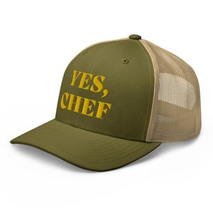 May include: A green and beige trucker hat with the text "YES, CHEF" embroidered in yellow.