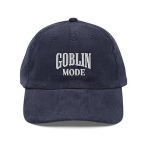 May include: A navy blue corduroy baseball cap with white embroidered text that reads "GOBLIN MODE".