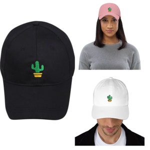 Op de afbeelding: Twee baseballpetten met een groene cactus geborduurd op de voorkant. De ene pet is zwart en de andere is wit.