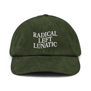 May include: A dark green corduroy baseball cap with the embroidered text "RADICAL LEFT LUNATIC" in white. The cap has a curved peak and a rounded crown. The hat is a solid colour and has a classic, casual style.