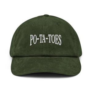 Op de afbeelding: Een groene corduroy baseballcap met de geborduurde tekst "PO-TA-TOES" in het wit. De cap heeft een gebogen klep en een gestructureerde kroon. De hoed is effen van kleur en heeft een klassieke, casual stijl.