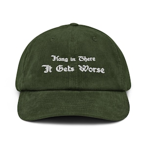 Può includere: Cappellino da baseball in velluto a coste verde scuro con visiera curva. Il cappellino presenta la scritta bianca ricamata "Hang in There It Gets Worse", con un font classico. Un accessorio casual.
