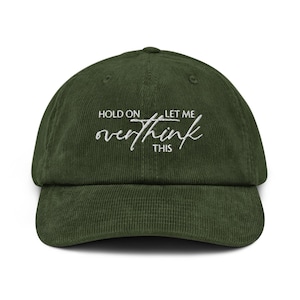 Puede incluir: Gorra de béisbol de pana verde oscuro con la frase bordada en blanco "HOLD ON LET ME overthink THIS". La gorra tiene una visera curva y una corona estructurada, adecuada para uso casual.