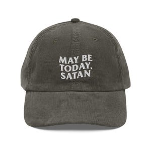 May include: Olive green corduroy baseball cap with the embroidered text "MAY BE TODAY, SATAN" in white. The cap has a curved brim and a rounded top.