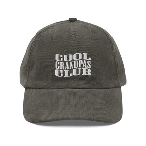 May include: A green corduroy baseball cap with white embroidered text that reads "COOL GRANDPAS CLUB".