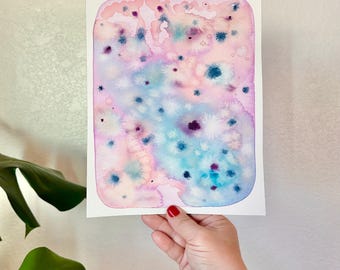 Könnte beinhalten: Abstrakte Aquarellmalerei mit rosa, blauem und weißem Hintergrund. Das Gemälde zeigt eine Vielzahl kleiner, bunter Punkte und Spritzer.