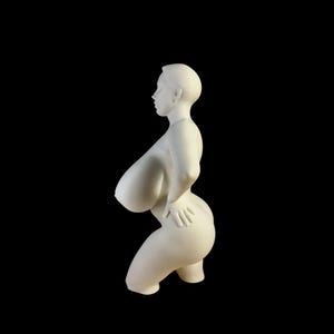 Könnte beinhalten: Eine weiße Skulptur einer Person in kniender Pose, mit einer Hand auf der Hüfte. Die Figur hat eine glatte, matte Oberfläche und ist vor einem schwarzen Hintergrund platziert.