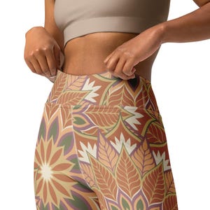 May include: High-waisted leggings with a colorful floral pattern in shades of brown, orange, green, and purple. The leggings have a tight fit and are made of a stretchy fabric.