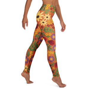 May include: Orange leggings with a floral pattern featuring yellow sunflowers, purple and yellow smaller flowers, and green leaves. The leggings are high-waisted and form-fitting.