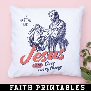 May include: White square cushion featuring a graphic illustration of Jesus healing a man. The word "Jesus" is in red script, with "33AD Over everything" below. The text "He Healed Me" is above the illustration. The words "Faith Printables" are at the bottom.