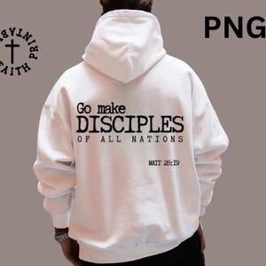 May include: White hoodie with the text "Go make DISCIPLES OF ALL NATIONS" and "MATT 28:19" printed in black. The hoodie has a drawstring hood and a kangaroo pocket. A circular logo with a cross and the words "PRINTABLES FAITH" is on the left.